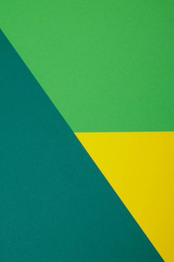 Farklı renklerde bir kağıdın çok renkli arkaplanı. Sarı, yeşil ve koyu yeşil renklerin karışımı. Geometrik arkaplan.