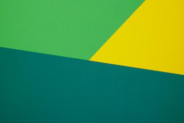 Farklı renklerde bir kağıdın çok renkli arkaplanı. Sarı, yeşil ve koyu yeşil renklerin karışımı. Geometrik arkaplan.
