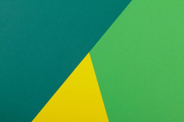 Farklı renklerde bir kağıdın çok renkli arkaplanı. Sarı, yeşil ve koyu yeşil renklerin karışımı. Geometrik arkaplan.