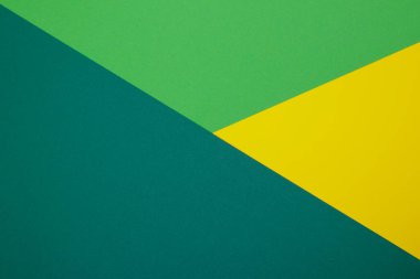 Farklı renklerde bir kağıdın çok renkli arkaplanı. Sarı, yeşil ve koyu yeşil renklerin karışımı. Geometrik arkaplan.