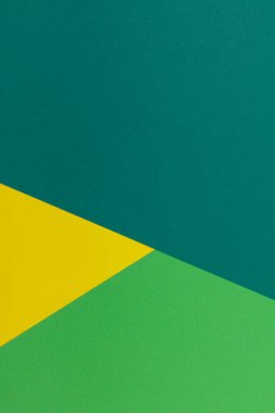 Farklı renklerde bir kağıdın çok renkli arkaplanı. Sarı, yeşil ve koyu yeşil renklerin karışımı. Geometrik arkaplan.
