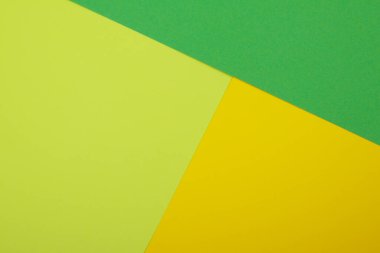 Farklı renklerde bir kağıdın çok renkli arkaplanı. Sarı, yeşil ve limon rengi karışımı. Geometrik arkaplan.