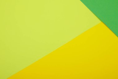 Farklı renklerde bir kağıdın çok renkli arkaplanı. Sarı, yeşil ve limon rengi karışımı. Geometrik arkaplan.