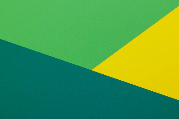 Multicolor background from a paper of different colors. Mix of yellow, green and dark green colors. Geometric backdrop.
