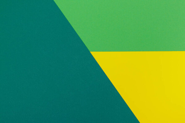 Multicolor background from a paper of different colors. Mix of yellow, green and dark green colors. Geometric backdrop.