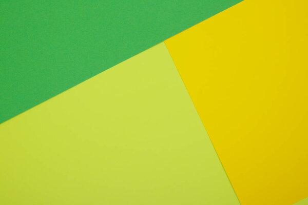 Multicolor background from a paper of different colors. Mix of yellow, green and lime colors. Geometric backdrop.