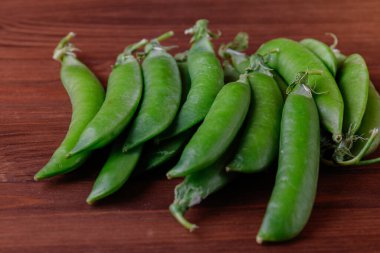 Tahta masada yeşil bezelye kabukları. Olgun bezelye.
