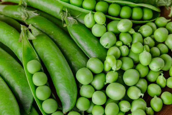 Green pea and pea pods. Peas background. Closeup of fresh pea. Pea pod with beans.