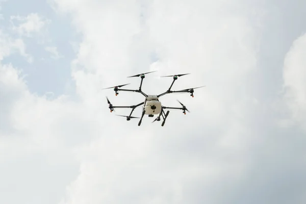 Octocopter in the sky. Professional agriculture drone in cloudy sky.