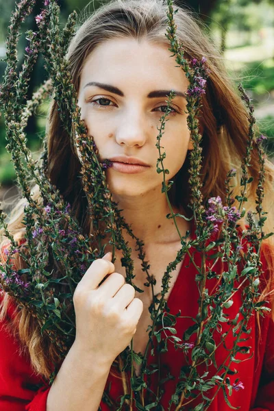Portret Brunetki Czerwonej Sukience Model Gospodarstwa Bukiet Dzikich Kwiatów Rękach — Zdjęcie stockowe