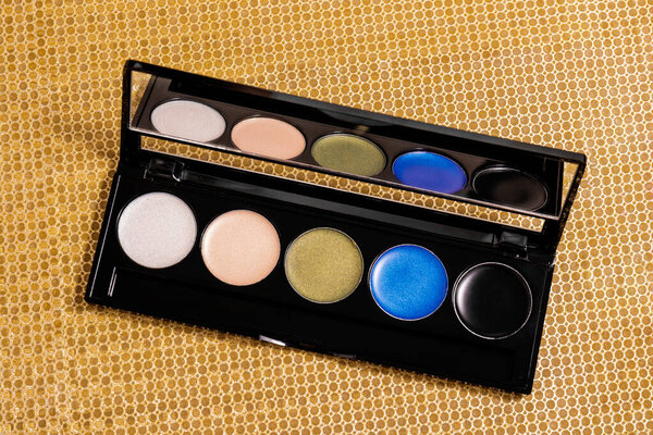 Makeup eyeshadow palette on the golden background. Makeup eyeshadow palette set.