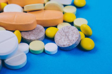 Tabletler ve haplar mavi arka planda. Çeşitli tedaviler. Çeşitli ilaçlar ve haplar. Kapatın. Makro. Tıbbi konsept.