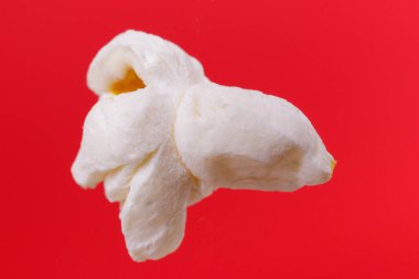 Kırmızı arka planda patlamış mısırın makro çekimi.