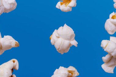 Mavi arka planda patlamış mısırın makro çekimi.