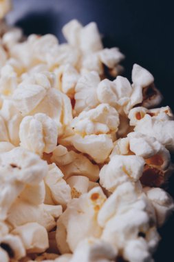 Siyah kasede patlamış mısır. Makro çekim.