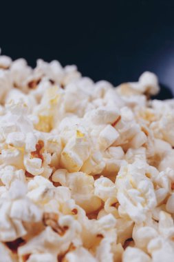 Siyah kasede patlamış mısır. Makro çekim.