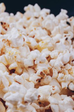 Siyah kasede patlamış mısır. Makro çekim.