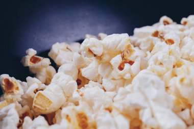 Siyah kasede patlamış mısır. Makro çekim.