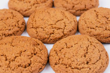 Beyaz arka planda tatlı yulaf ezmeli kurabiyeler.