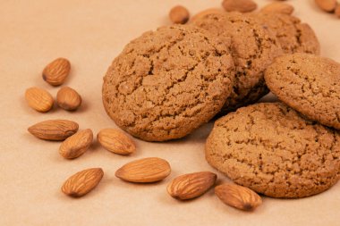 Bej arkaplanda yulaf ezmeli kurabiye ve badem..