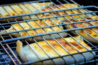 Mürekkep balığı leşleri ızgarada pişirilir..