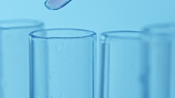 피펫에서 실험실 실험용 튜브로 떨어지는 물방울 — 비디오