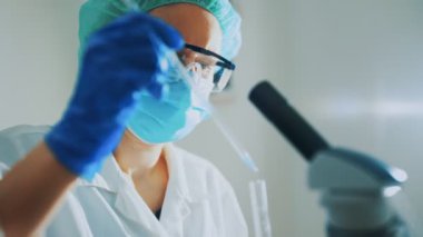 Laboratuvarda test tüpleriyle çalışan kadın bilim adamı..