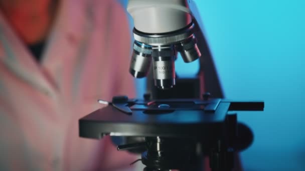 Επιστήμονας Στην Ιατρική Μάσκα Που Εργάζεται Μικροσκόπιο Στο Εργαστήριο — Αρχείο Βίντεο