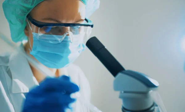 实验室内带显微镜的医用面罩科学家 — 图库照片