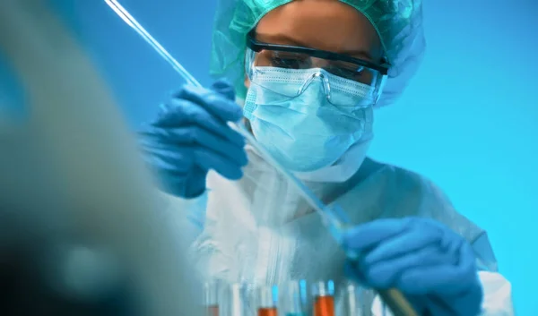 戴护目镜和面罩的妇女在实验室与试管一起工作 — 图库照片