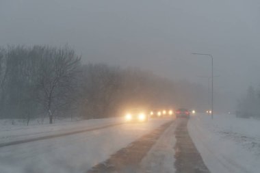 Arabalar zor hava koşullarında yolda ilerler. Kar Fırtınası.