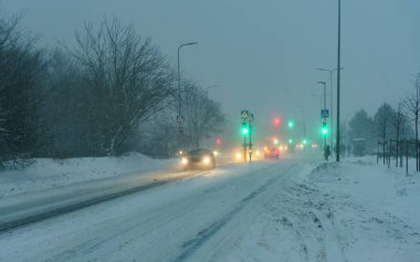 Arabalar zor hava koşullarında yolda ilerler. Kar Fırtınası.
