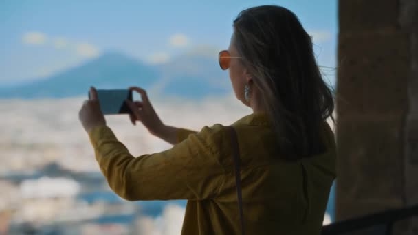 女性は彼女の電話でナポリとヴェスヴィオ山の景色を撮影します — ストック動画
