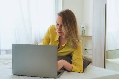 Kadın yatak odasındaki bilgisayarda çalışıyor..