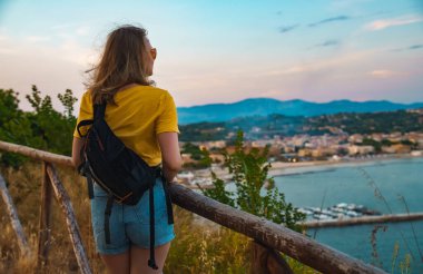 Woman tourist with backpack visits the nature reserve park.