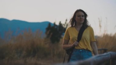 Woman tourist with backpack visits the nature reserve park.