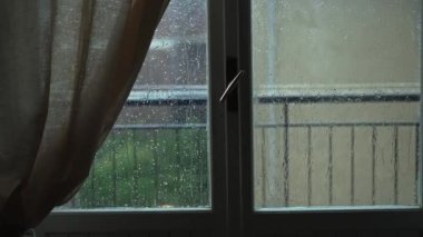 Heavy rain outside the window. Bad weather.