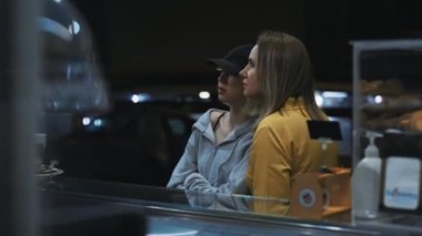 Mom and her daughter order food in street truck.