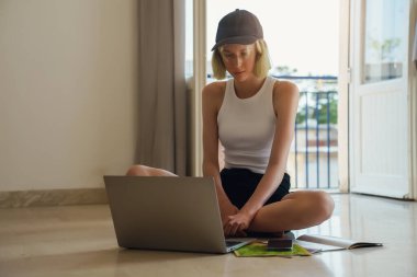 Teenage girl doing her homework with laptop.