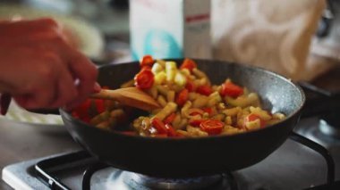 Zucchini with carrots and onions frying in pan.