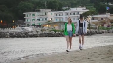 Family walking and talking on the beach.