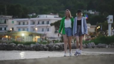 Family walking and talking on the beach.