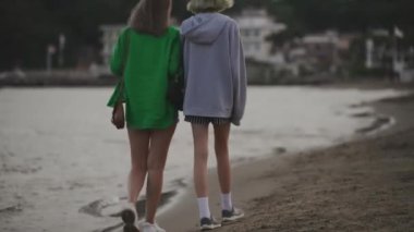 Family walking and talking on the beach.