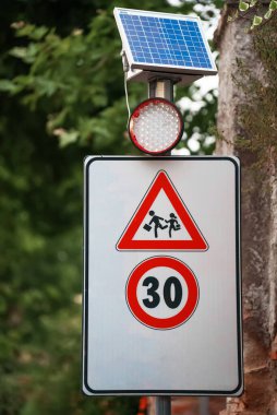 Caution school sign with lamp signal.