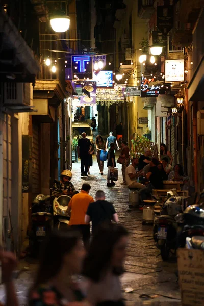 Naples, Italy - 11.06.2022: Crowdy night street in the old town.