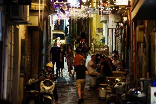 Naples, Italy - 11.06.2022: Crowdy night street in the old town.