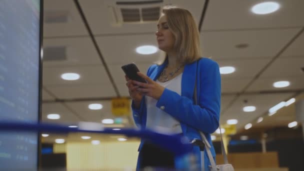 Жінка Діловому Костюмі Перевірці Свого Польоту Аеропорту — стокове відео