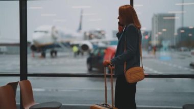İş elbiseli kadın havaalanında ayrılışını bekliyor..