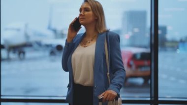 İş elbiseli kadın havaalanında ayrılışını bekliyor..