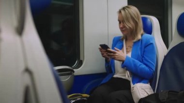 Woman in business suit with phone travelling by the train.